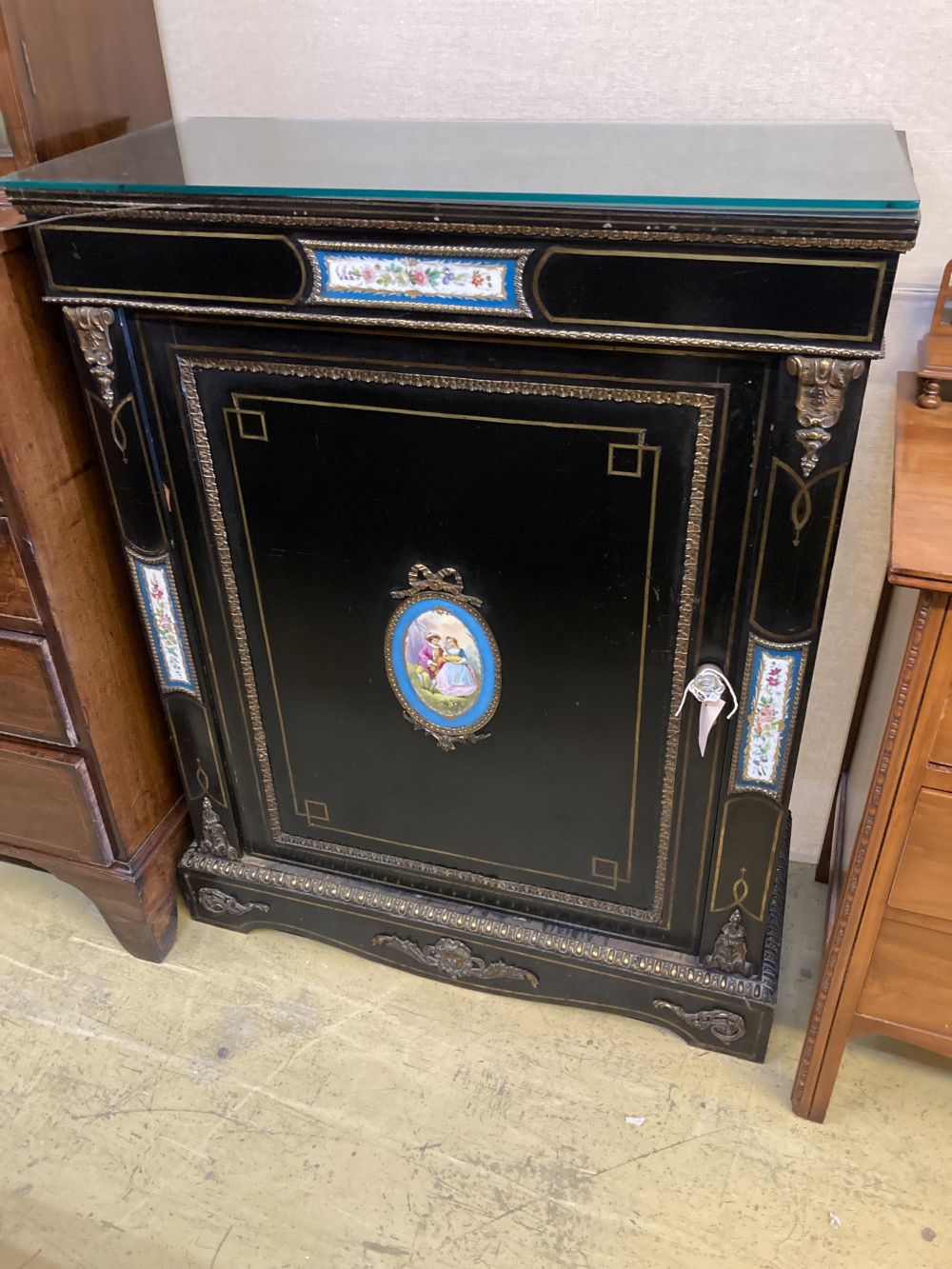 A late Victorian gilt metal and porcelain mounted ebonised pier cabinet, width 84cm, depth 38cm, height 106cm